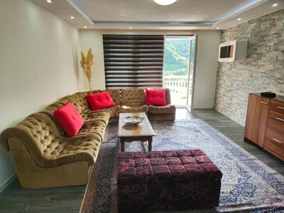 a living room with a brown couch and red pillows at Rooms Mery in Visoko