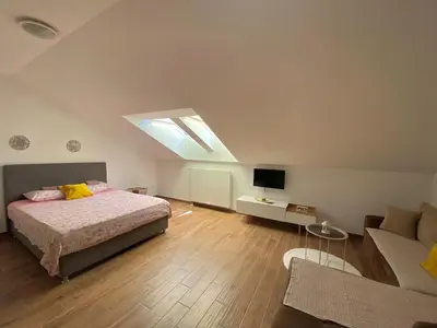 a bedroom with a bed and a tv and a couch at Apartman AndjelA in Banja Luka