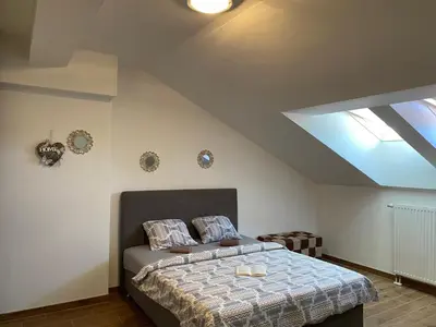 a bedroom with a bed with a blue comforter at Apartman AndjelA in Banja Luka