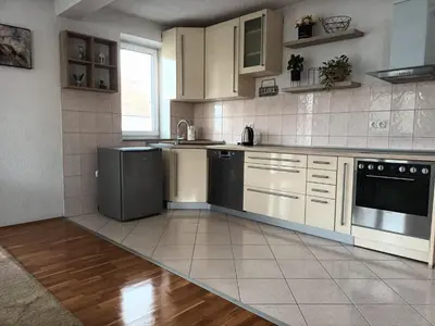 a kitchen with white cabinets and black appliances at Mia in Tomislavgrad