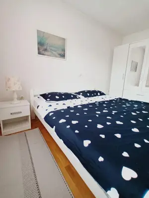 a bedroom with a bed with a blue and white comforter at Mia in Tomislavgrad