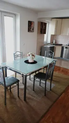 a dining room table with chairs and a vase of flowers on it at Mia in Tomislavgrad