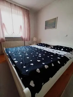a bedroom with a bed with a black blanket with white hearts at Mia in Tomislavgrad