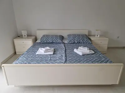 a bedroom with a white bed with two towels on it at Villa Sunset in Podastrana