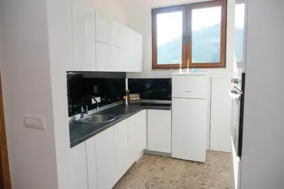 a kitchen with white cabinets and a sink and a window at Penthouse in Jajce