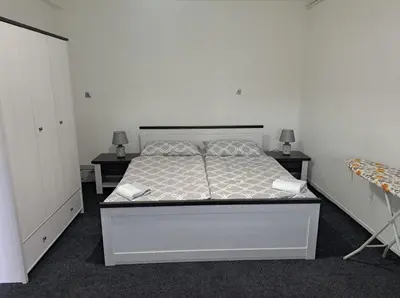 a bedroom with a bed with two tables and two lamps at Apartman Ivo in Livno