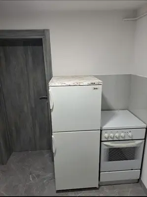 a small kitchen with a white refrigerator and a stove at Apartman Ivo in Livno