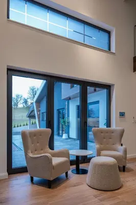 two chairs and a table in a room with windows at Villa 4A Visoko in Visoko