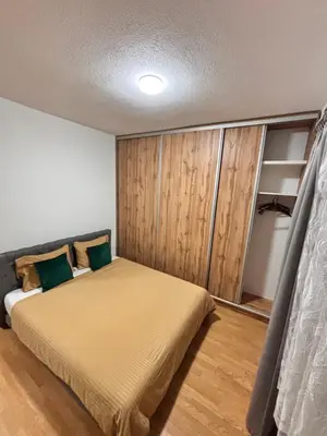 a bedroom with a bed with a wooden wall at Old Town Central in Banja Luka