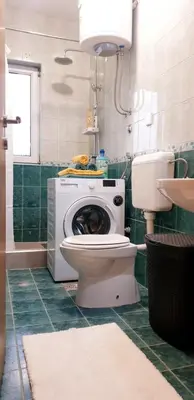 a bathroom with a toilet and a washing machine at Old Town Central in Banja Luka