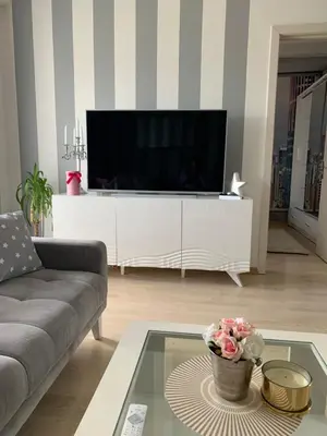 a living room with a large television on a white entertainment center at Apartment Sweet Home Banja Luka in Banja Luka