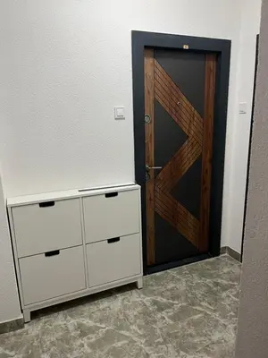 a closet with a wooden door and a dresser at Stan na dan, Pazar Tuzla - centar grada in Tuzla