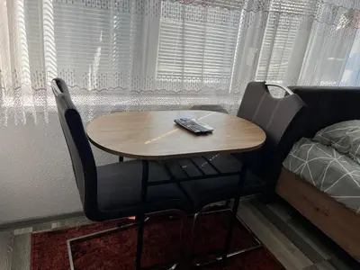 a table with two chairs and a remote control on it at Stan na dan, Pazar Tuzla - centar grada in Tuzla