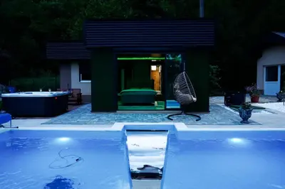 a swimming pool in front of a house at Villa Tasnim in Dobrenica