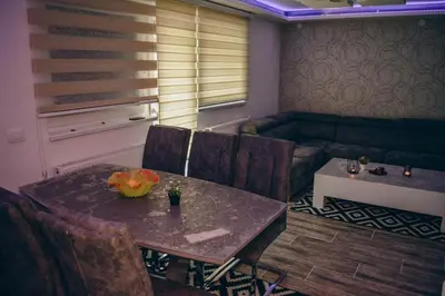 a dining room with a table and chairs and a couch at Villa Tasnim in Dobrenica