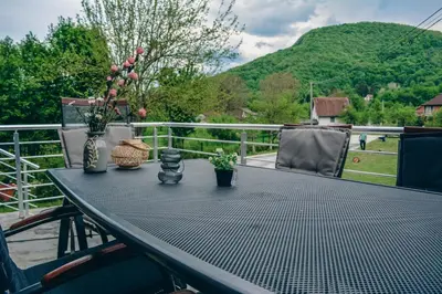 a table with vases and flowers on a balcony at Villa Tasnim in Dobrenica