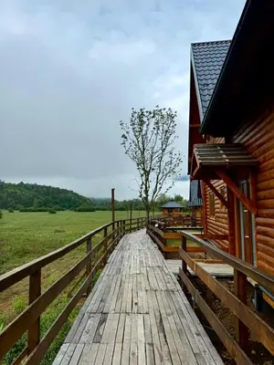 a wooden walkway next to a building next to a field at Bungalow Fly Fishing Kljuc River Sanica in Zolaći