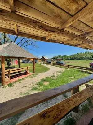 a wooden fence with a picnic table and a field at Bungalow Fly Fishing Kljuc River Sanica in Zolaći