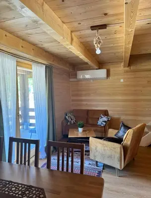 a living room with a couch and a table at Bungalow Fly Fishing Kljuc River Sanica in Zolaći