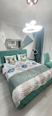 a bedroom with a bed and a chandelier at Apartman Kan in Bihać