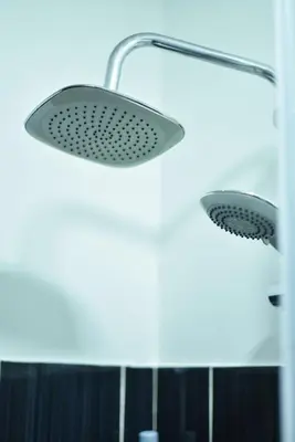two lights in a bathroom with a shower at Apartman Kan in Bihać