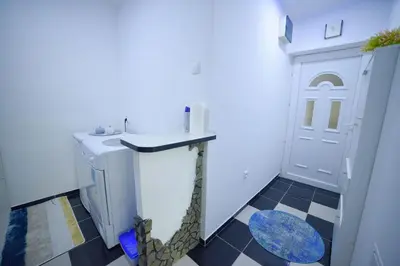 a laundry room with a washer and dryer and a door at Apartman Kan in Bihać