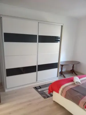 a bedroom with a bed and a table at Apartman Deni in Tuzla