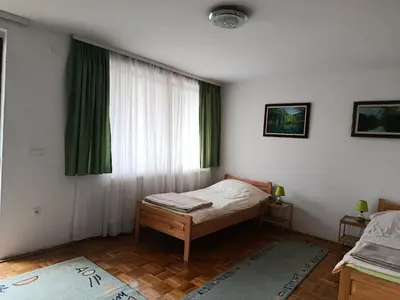 a bedroom with a bed and a window with green curtains at Sunshine Apartments Visoko in Visoko