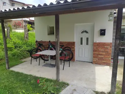 a patio with a table and chairs and a white door at Lenilenii Bungalow in Jajce