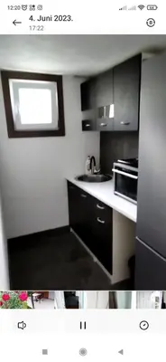 a kitchen with black and white cabinets and a microwave at Lenilenii Bungalow in Jajce