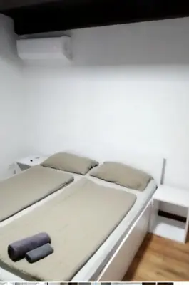 a bed in a room with a white wall at Lenilenii Bungalow in Jajce