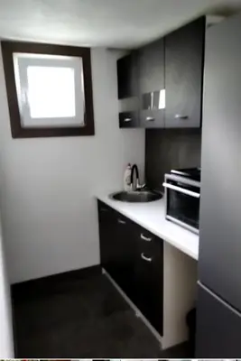 a small kitchen with a sink and a microwave at Lenilenii Bungalow in Jajce