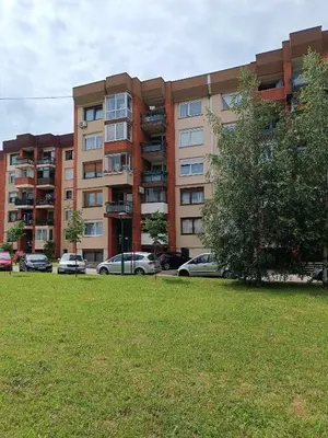 a large apartment building with cars parked in a park at Perfect Place in Visoko