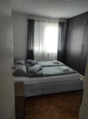 a bedroom with a large bed with a window at Perfect Place in Visoko
