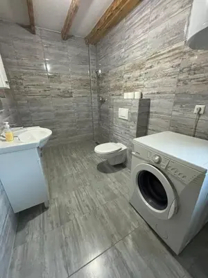 a bathroom with a washing machine and a toilet at Pool & Rest Holiday Home 3D in Bihać