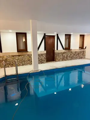 a swimming pool with blue water in a building at Pool & Rest Holiday Home 3D in Bihać