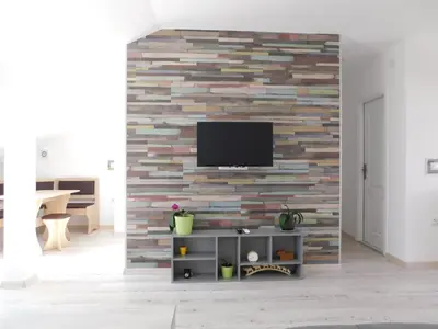 a living room with a tv on a brick wall at Tina apartman in Prnjavor