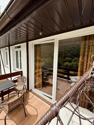a screened in porch with a table and chairs at Apartments & Homes with the river Una view in Bihać