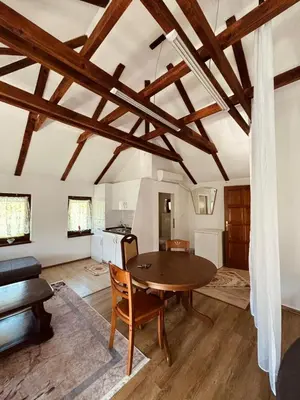 a living room with a wooden table and a kitchen at Apartments & Homes with the river Una view in Bihać