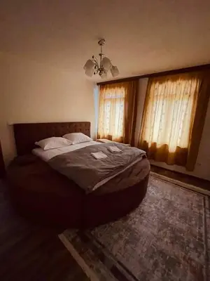 a bedroom with a large bed with two windows at Apartments & Homes with the river Una view in Bihać
