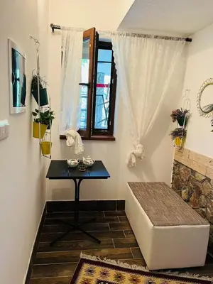 a room with a table and a bench and a window at Apartments & Homes with the river Una view in Bihać