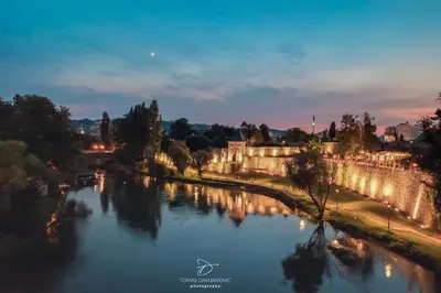 a view of a river with a castle and a bridge at Riverside Panorama Apartment 2 near City Center Brko 2 in Banja Luka