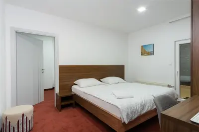 a bedroom with a large bed with a wooden headboard at Stan lux Kašmir in Bugojno