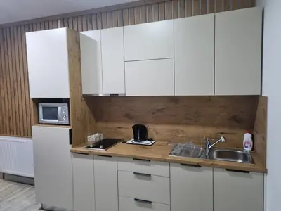 a kitchen with white cabinets and a sink at Stan lux Kašmir in Bugojno