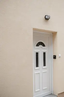 a white door on the side of a building at Apartmani Romić R in Novi Travnik