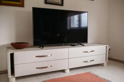 a flat screen tv on a white dresser in a living room at Apartmani Romić R in Novi Travnik