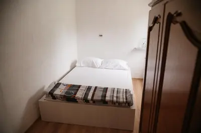 a small bed in a small room with a drawer at Apartmani Romić R in Novi Travnik