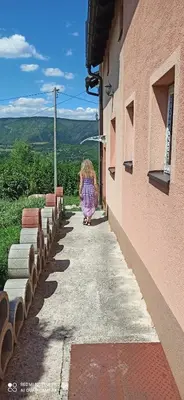 a girl walking down a sidewalk next to a building at Vila Brdjanka in Šipovo