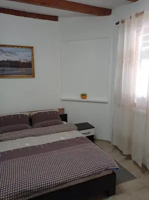 a bedroom with a bed and a window with curtains at Kuca za odmor Zlaja in Bihać