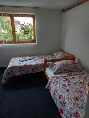 a bedroom with two beds and a window at Guest House Visoko in Visoko